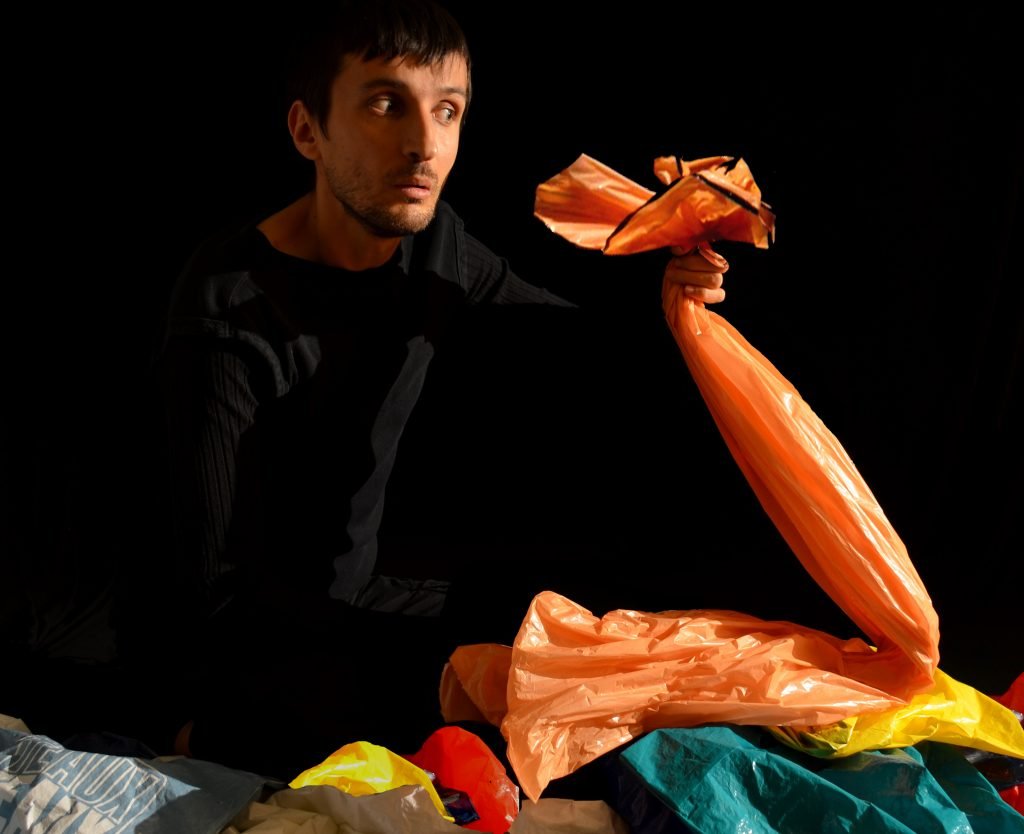 Bridges Festival artist Csaba Raduly holding an orange plastic bag puppet during the show Plastique presented during march break