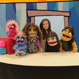 Bridges Festival presents a puppeteer from Steven Botelho's Our Space next to her five puppets during march break