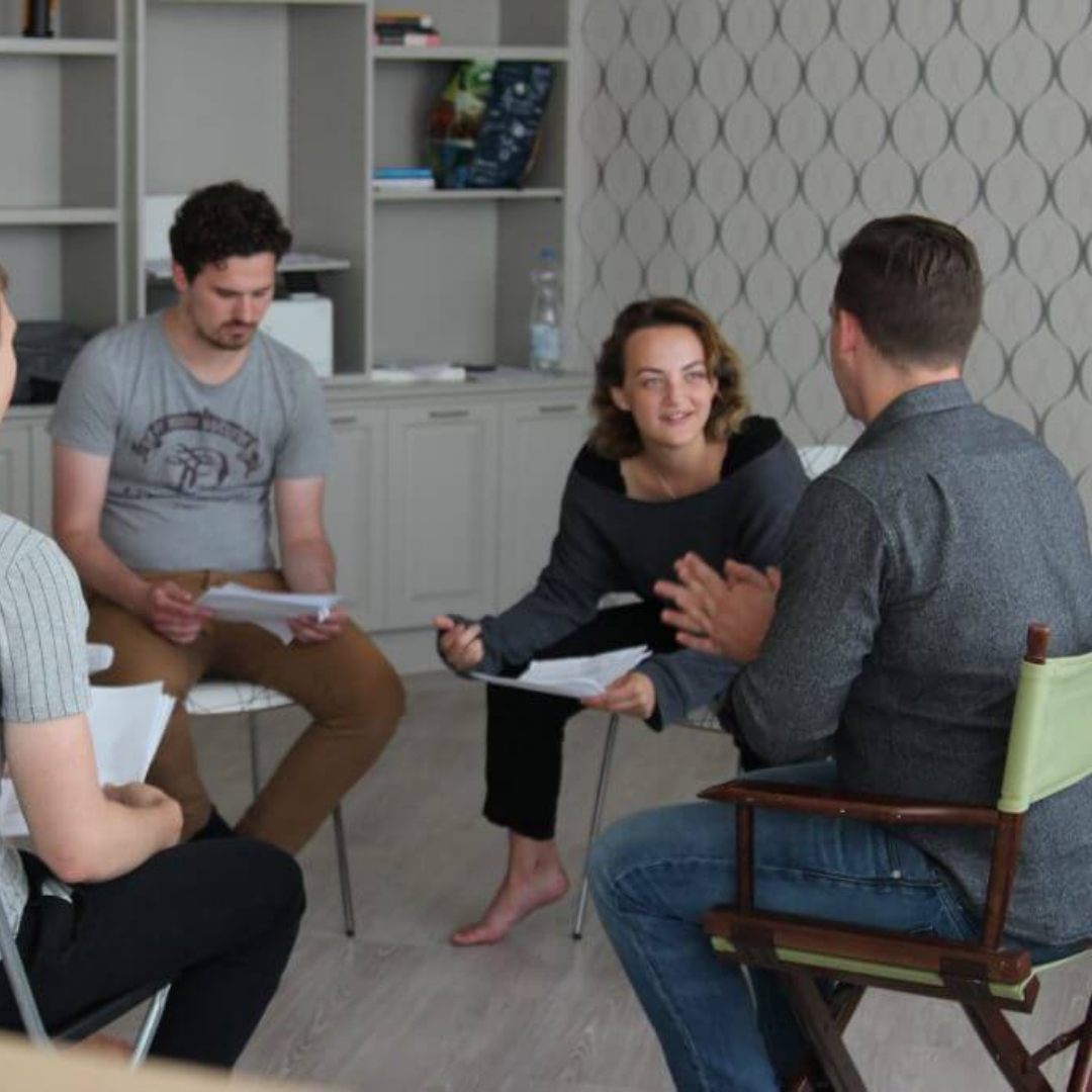 People sitting on chairs in a circle while reading a play together, participating in live events in Mississauga and activities in Mississauga